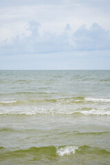 Pastel colored Baltic sea on a sunny late summer day with blue sky and green water with small waves, Latvia