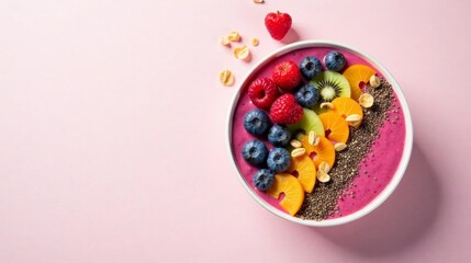 A vibrant pink smoothie bowl brimming with fresh raspberries, blueberries, kiwi, and mandarin orange slices, garnished with chia seeds and crunchy oat flakes, presented on a soft pink backdrop.