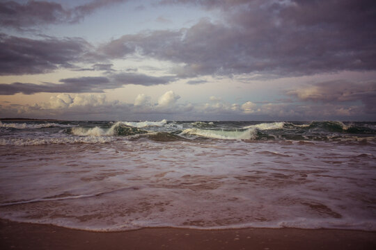 Waves crashing on the beach under a brooding sky