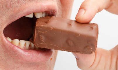 A man is eating a chocolate bar