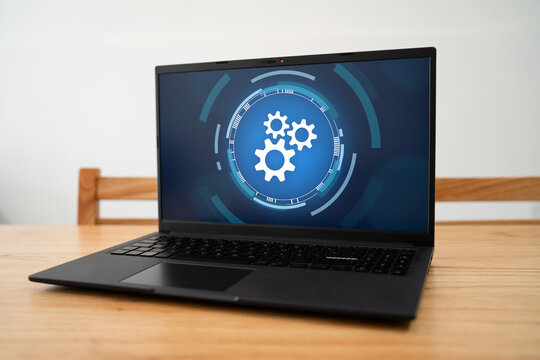 Laptop running automation process. Concept of automate task with gears icon on screen.