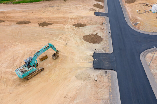 Aerial view of roads and house blocks and machinery in a new housing subdivision