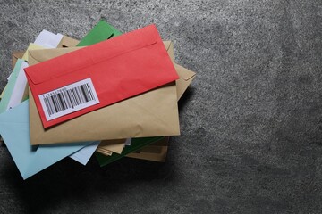 Post office. Stack of different paper envelopes on dark grey table, top view. Space for text