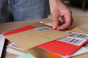 Woman with many different envelopes at table in post office, closeup