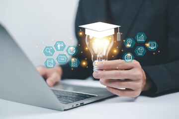 E-learning concept, Businessman showing e-learning icon holding a bright light bulb. Learning...