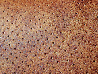 Macro texture of light brown leather, leather background and small hole