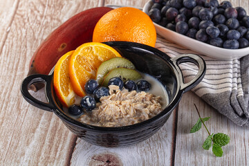 Oats porridge with blueberry, kiwi and orange