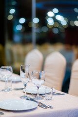 A stunning table awaits guests, complete with elegant glassware, fine cutlery, and soft lights