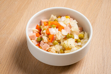Colorful mix of chopped vegetables, ham, and peas creates a refreshing summer salad bowl