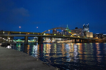 Pittsburgh, Pennsylvania, USA &ndash; March 25, 2024: Night view of downtown Pittsburgh with the Fort Duquesne Bridge and city lights reflecting on the Allegheny River as seen from the North Shore Riverwalk