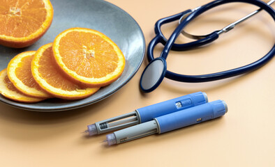 Two Insulin injection pen for diabetics and weight loss and plate with orange