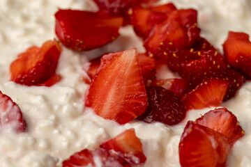 cottage cheese with sour cream and strawberries, cottage cheese with strawberries cut into pieces, closeup, side view