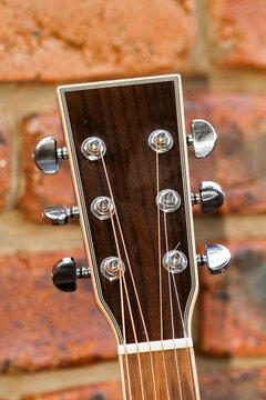 Acoustic guitar headstock showing string tuners.