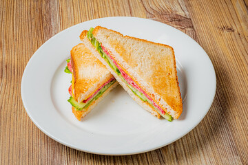 A scrumptious sandwich featuring layers of ham, cheese, and crisp greens, perfectly toasted