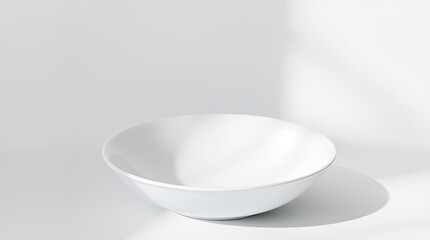 A simple white ceramic bowl sitting on a bright white surface