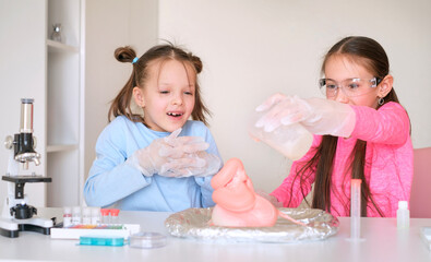 Children conduct an experiment with the eruption of a foam volcano