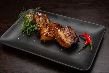 Stewed meat with sesame on a black plate, Japanese cuisine