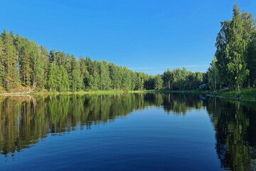 Beautiful lakescape on Summer. Calm water with reflection. Location: Lake Osmajarvi, Leppavirta, Finland.