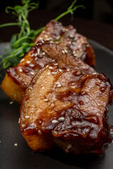 Stewed meat with sesame on a black plate, Japanese cuisine