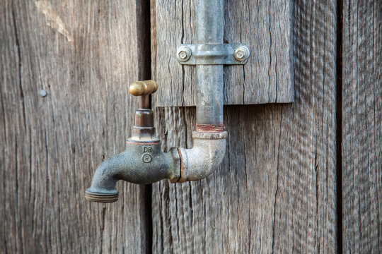 Metal tap fitting on side of wood shed