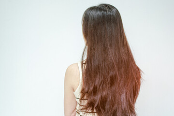 The back view of a woman showing her messy hair with visible split ends and damage.