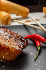 Stewed meat with sesame on a black plate, Japanese cuisine