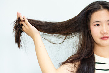 Closeup portrait of female model holding messy hair in hands, Combing with brush and pulls long hair, Daily preparation for looking nice, Long Disheveled Hair, Holding Messy Hair