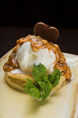 Dessert with puff pastry and ice cream drizzled with caramel on a plate