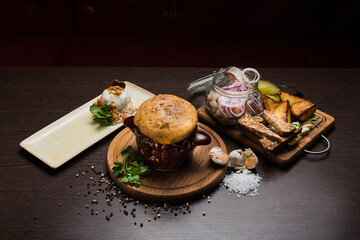 Set of Belarusian cuisine from a pot with herring meat with onions and dessert