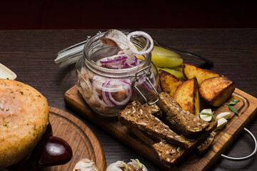 Set of Belarusian cuisine from a pot with herring meat with onions and dessert
