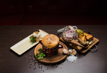 Set of Belarusian cuisine from a pot with herring meat with onions and dessert