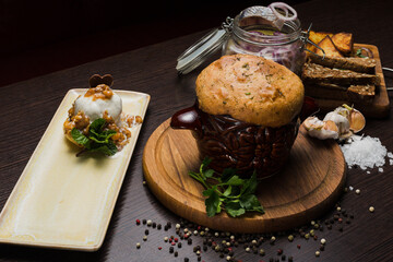Set of Belarusian cuisine from a pot with herring meat with onions and dessert