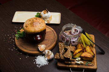 Set of Belarusian cuisine from a pot with herring meat with onions and dessert