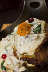 Draniki with chanterelle mushrooms, cream sauce and meat