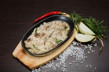 Meat in a creamy sauce with mushrooms and cheese
