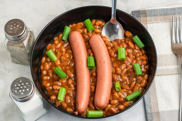 hot dogs  on baked beans top with green onions