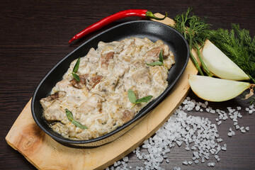 Meat in a creamy sauce with mushrooms and cheese