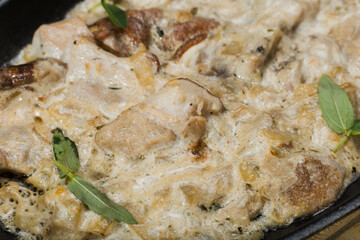 Meat in a creamy sauce with mushrooms and cheese