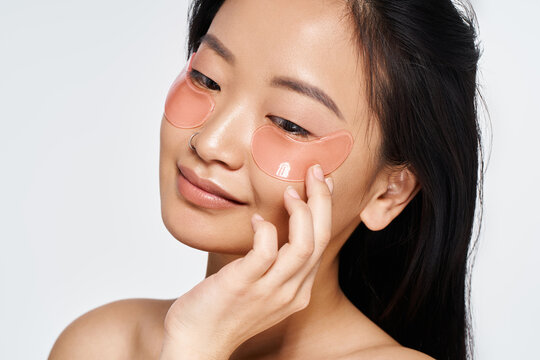 Relaxing skin care routine featuring a young beautiful Asian woman enjoying rejuvenating patches