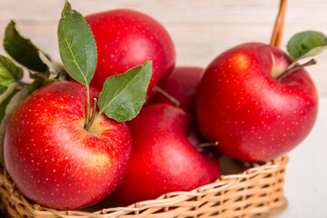 Ripe garden apple fruits with leaves in basket on wooden table. Top view flat lay with copy space