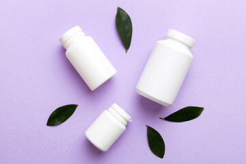 supplement pills with medicine bottle health care and medical top view. Vitamin tablets. Top view mockup bottle for pills and vitamins with green leaves, natural organic bio supplement, copy space