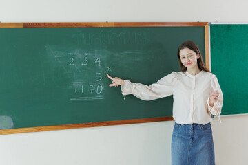 Diversity in education with teacher studying math lesson on chalkboard in classroom