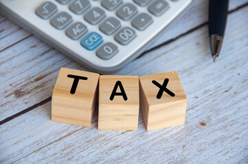 Top view of Tax Time text on wooden cubes with calculator background