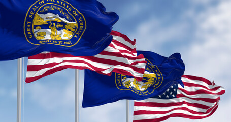 Nebraska and US flags waving in wind with state seal, 3D render