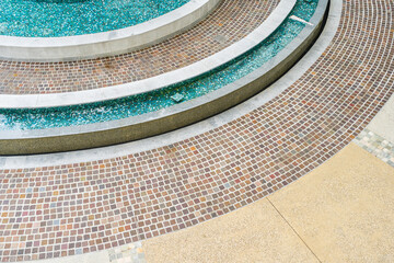 Close up of mosaic tiles on the curved wall of a fountain