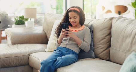 Fototapeta premium Sofa, kid and girl with smartphone for game, streaming online and watching video on social media. Home, female person and child with mobile for application, digital reel and relax with smile on couch