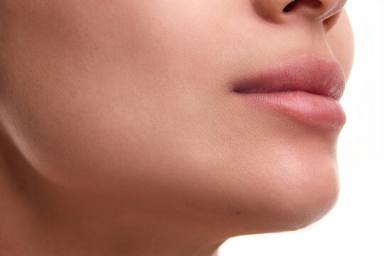 Cropped close-up image of beautiful female spotless face with plump pink lips, perfect chin line. Aesthetic ideals, lifting, plastic surgery, facial contouring. No double chin. Concept of beauty