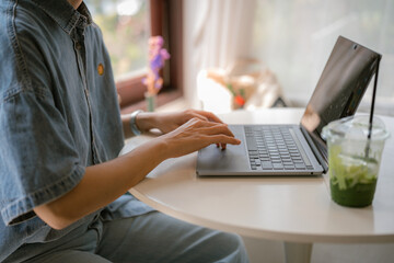 person working on laptop, hands of female typing on keyboard.