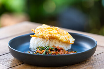 Spicy fried pork with basil leaves, the famous traditional Thai food served with jasmine rice and fried egg.