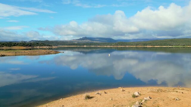 Beautiful drone view landscape with a lake of calm waters and reflections of clouds in the water, El Atazar, Madrid